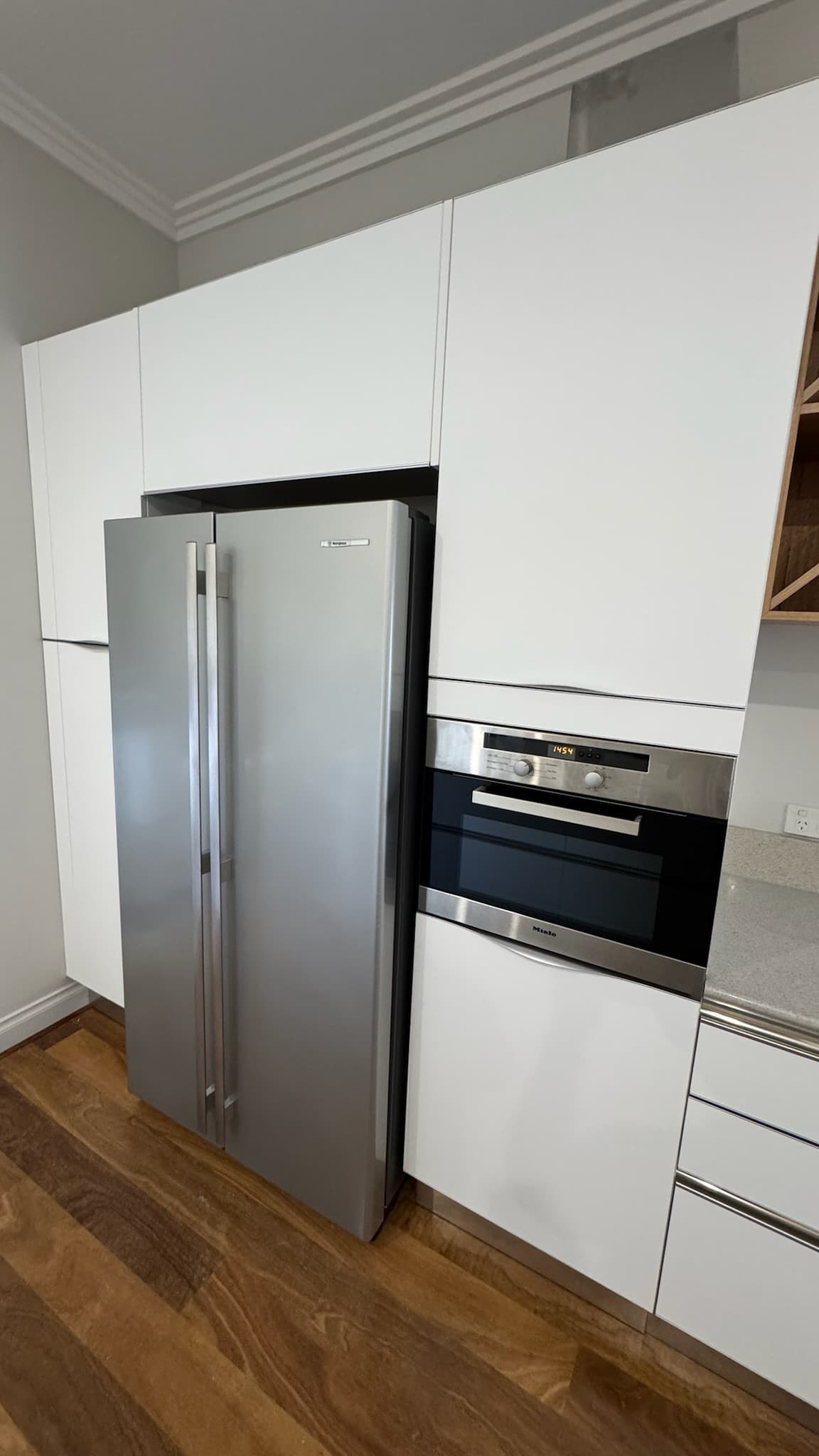 Crisp white wrapped kitchen with stainless appliances after refresh