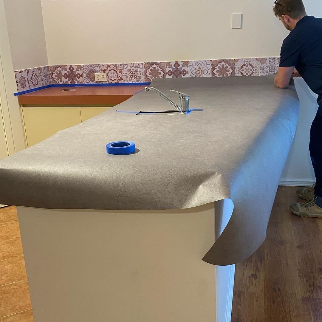 Stone-look vinyl being applied to an existing kitchen benchtop